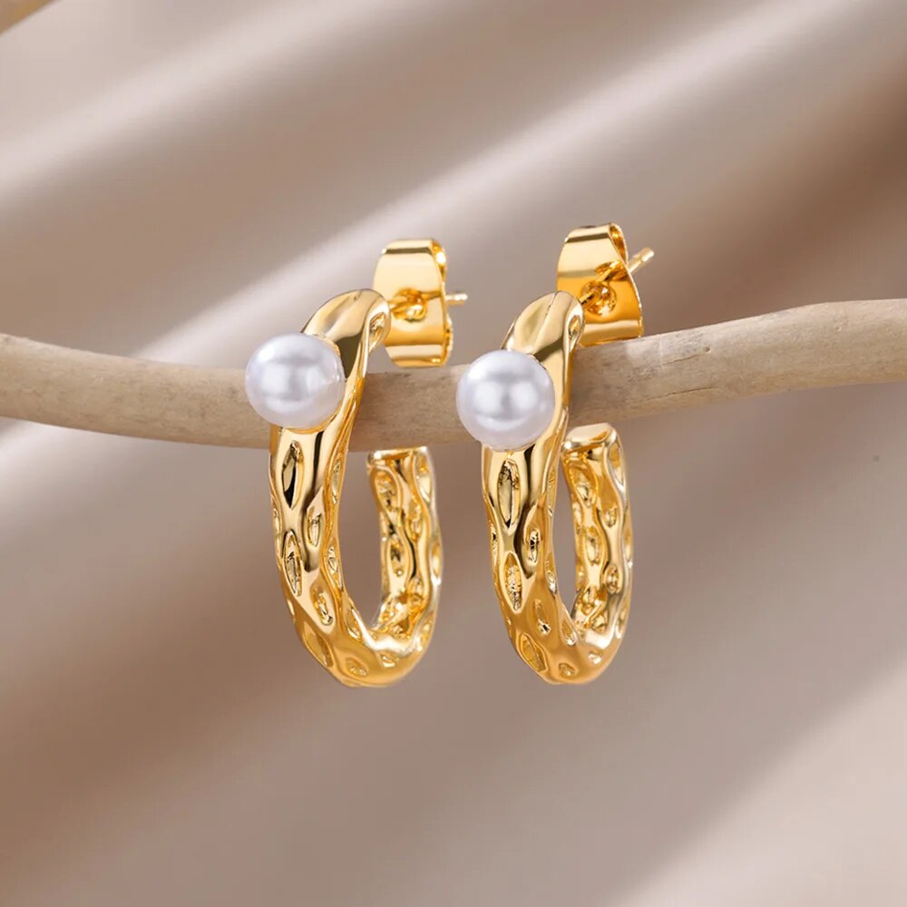 Bellos aretes dorados con diseños elegantes de mariposas, perlas y otros