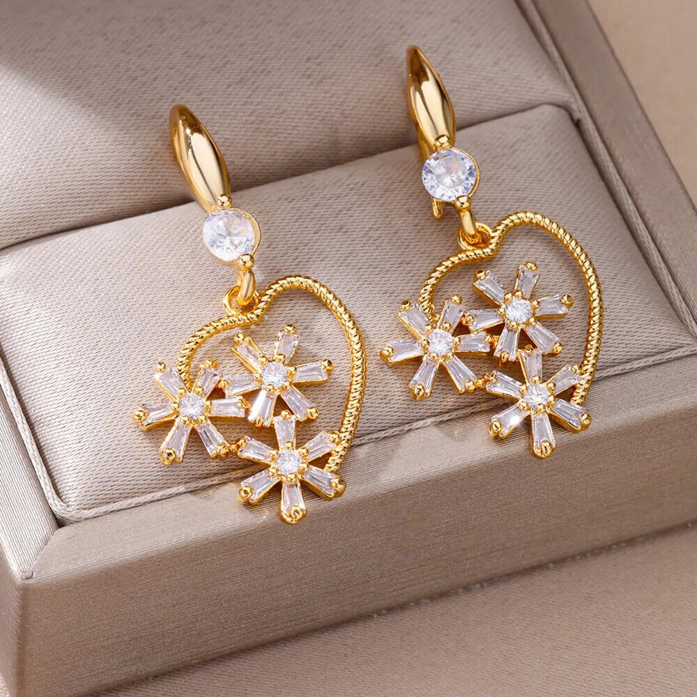 Bellos aretes dorados con diseños elegantes de mariposas, perlas y otros