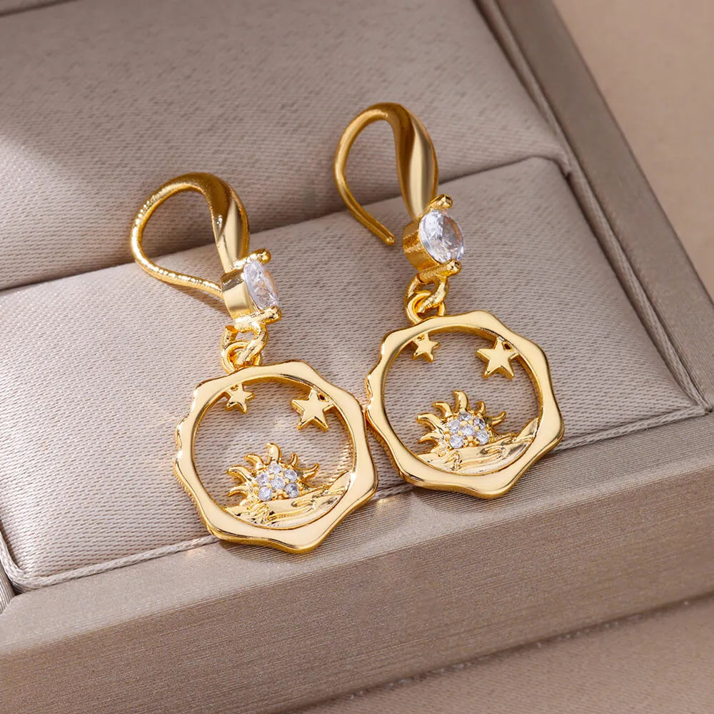 Bellos aretes dorados con diseños elegantes de mariposas, perlas y otros