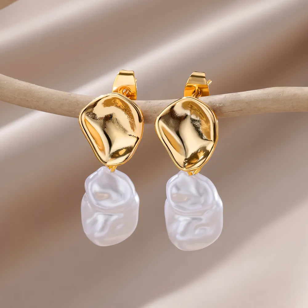 Bellos aretes dorados con diseños elegantes de mariposas, perlas y otros