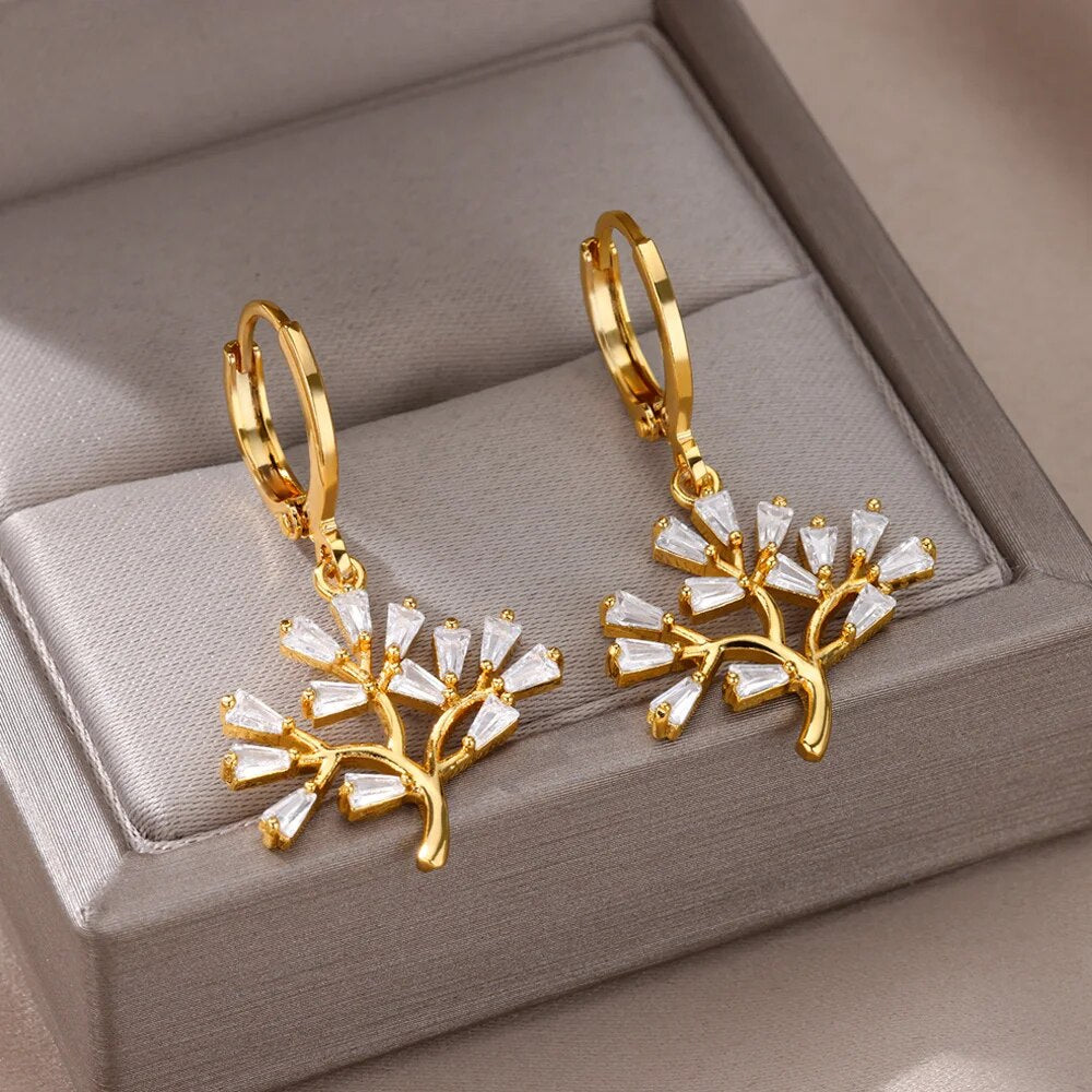 Bellos aretes dorados con diseños elegantes de mariposas, perlas y otros