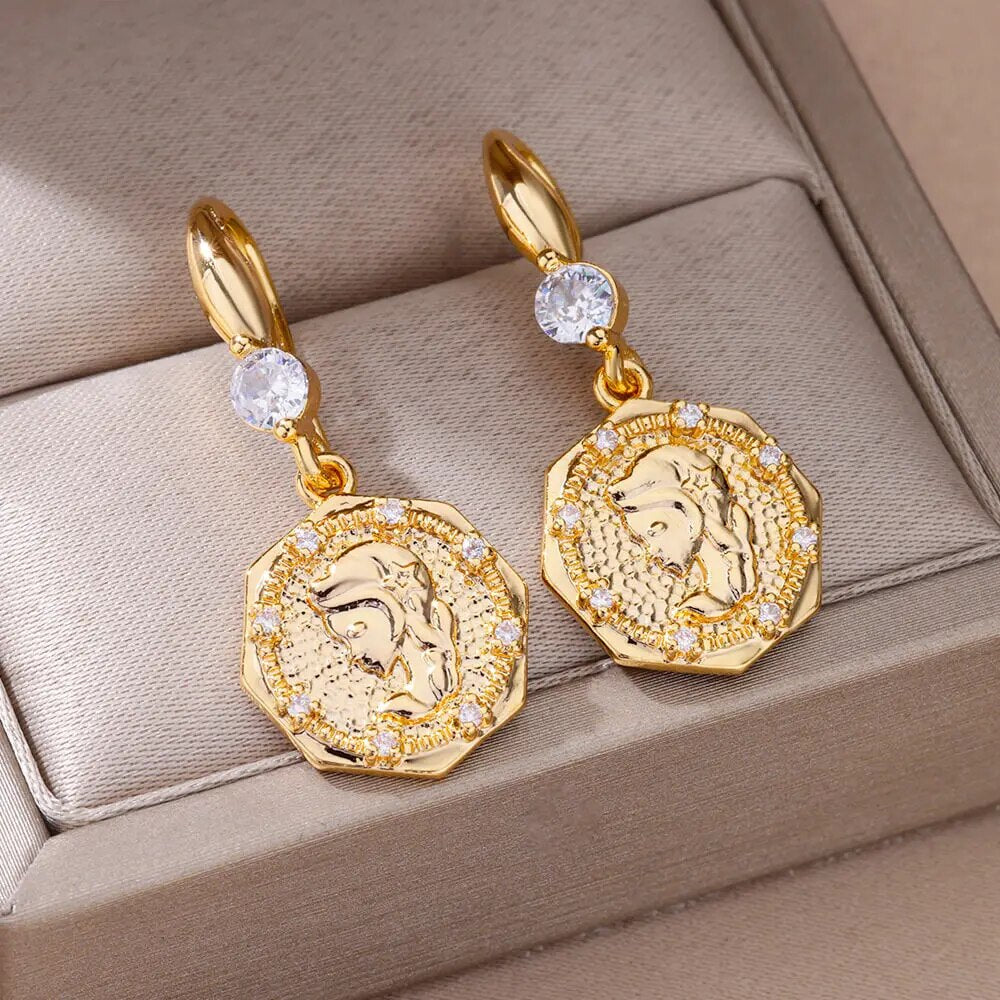 Bellos aretes dorados con diseños elegantes de mariposas, perlas y otros