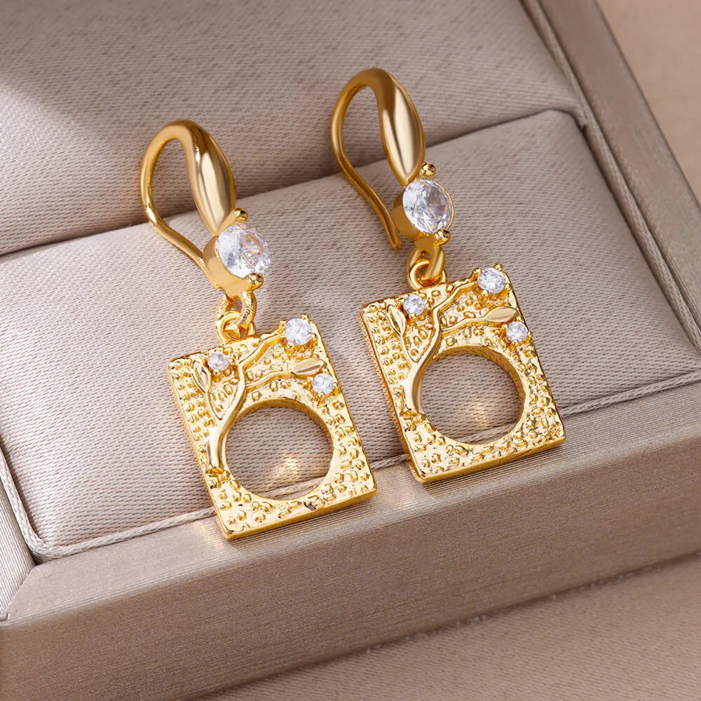 Bellos aretes dorados con diseños elegantes de mariposas, perlas y otros