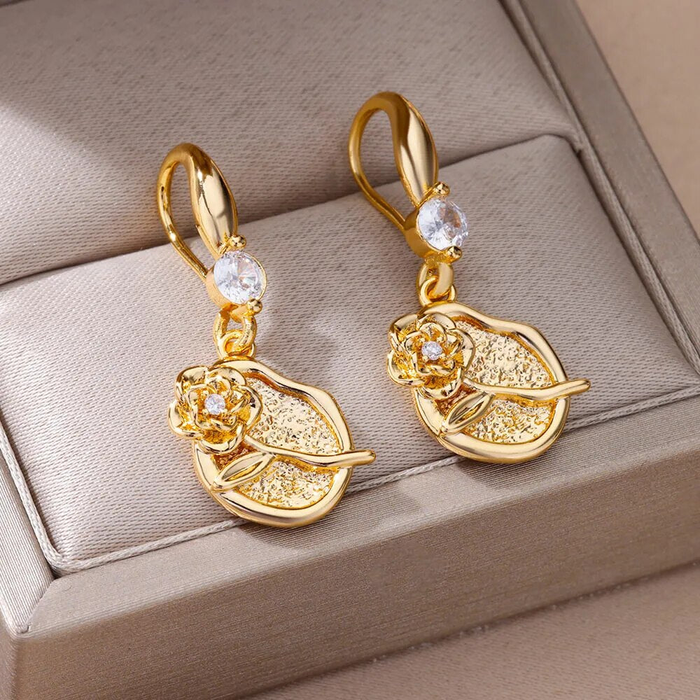 Bellos aretes dorados con diseños elegantes de mariposas, perlas y otros