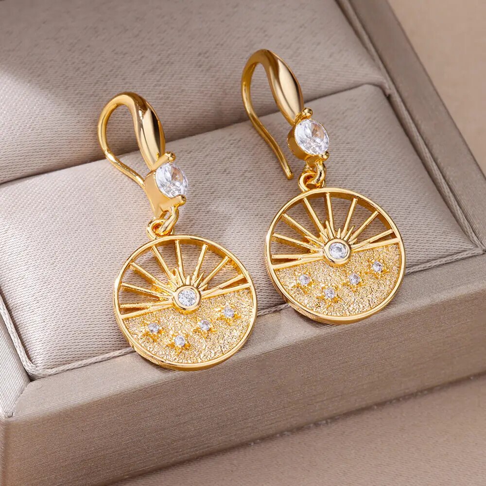 Bellos aretes dorados con diseños elegantes de mariposas, perlas y otros