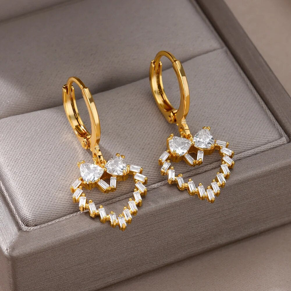 Bellos aretes dorados con diseños elegantes de mariposas, perlas y otros