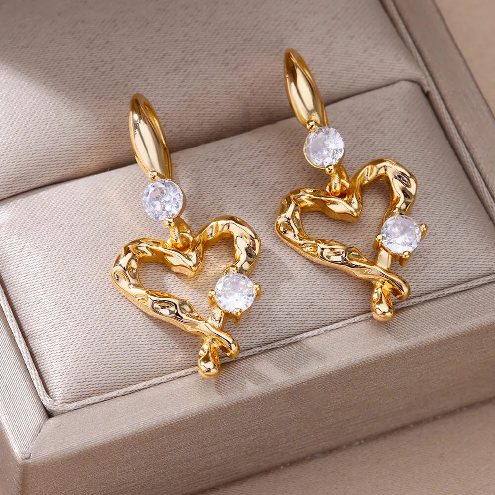 Bellos aretes dorados con diseños elegantes de mariposas, perlas y otros