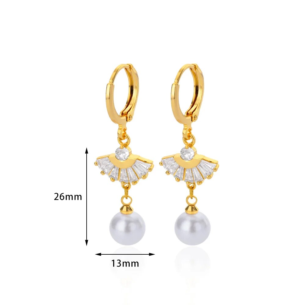 Bellos aretes dorados con diseños elegantes de mariposas, perlas y otros